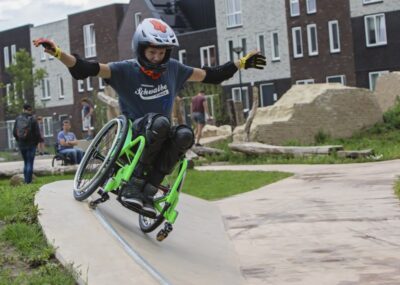 jongen in rolstoel balancerend op skateboard helling